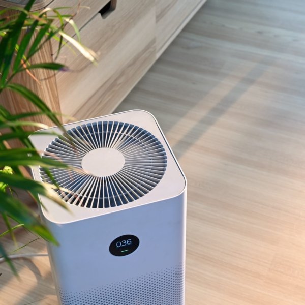 Air purifier on wooden floor in comfortable home. Fresh air and healthy life.
